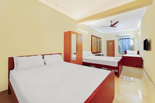 a bedroom with two beds and a bathroom at Hotel Yadvik in Chennai