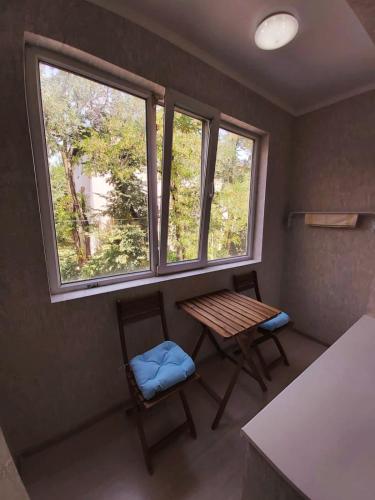 a room with a table and two chairs and a window at Отличная квартира со всеми удобствами. in Almaty