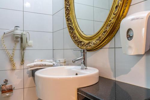 a bathroom with a sink and a mirror at Residence Hotel By Ketenci in Izmir