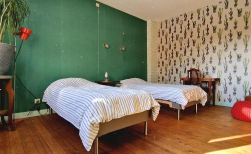 two beds in a room with a green wall at Vakantiewoning in Mol centrum met eigen bar "CasaCuriosa" in Mol