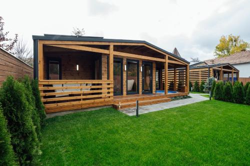 une grande maison en bois avec une cour verdoyante dans l'établissement Telegdy Homes, à Praid