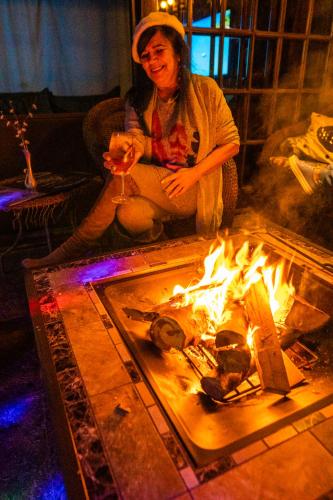 a woman sitting in front of a fire at Gajah in Joinville