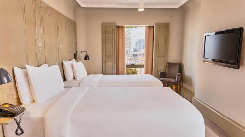 a hotel room with two beds and a television at The Cettia Istanbul in Istanbul