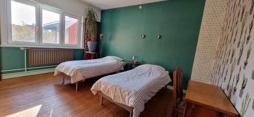 2 camas en una habitación con paredes verdes en Gastenkamers in vakantiewoning CasaCuriosa, en Mol