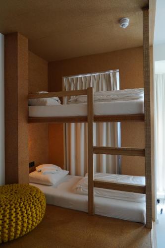 a bunk bed with three bunk beds in a room at the bellhop in Rotterdam