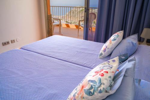 sypialnia z łóżkiem z niebieską pościelą i balkonem w obiekcie Balcon del Mar w mieście Puerto Rico de Gran Canaria