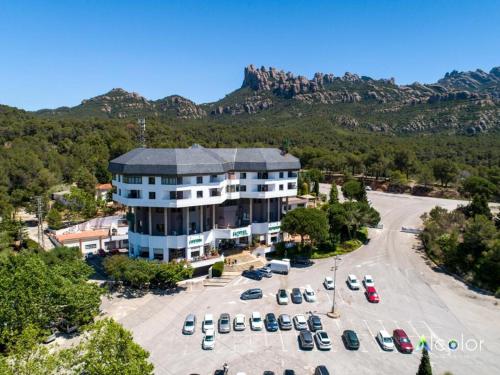 eine Luftansicht auf ein großes Gebäude mit einem Parkplatz in der Unterkunft Hotel Bruc in El Bruc