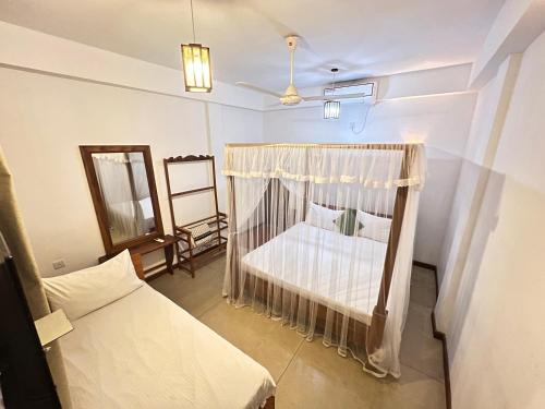 a bedroom with a bed and a couch and a mirror at Heavens Holiday Resort in Kandy