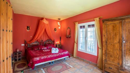 a red bedroom with a bed and a window at Casa Mulera Alozaina by Ruralidays in Alozaina