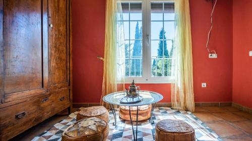 a room with a table and two stools and a window at Casa Mulera Alozaina by Ruralidays in Alozaina