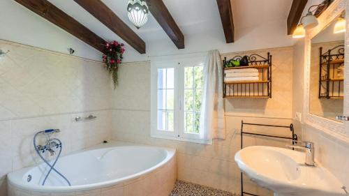 ein Bad mit einer Badewanne, einem Waschbecken und einem Fenster in der Unterkunft Casa Mulera Alozaina by Ruralidays in Alozaina