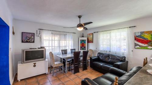 a living room with a table and a television at Casa Mulera Alozaina by Ruralidays in Alozaina