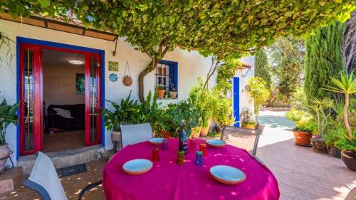 a table with a red table cloth on a patio at Casa Mulera Alozaina by Ruralidays in Alozaina