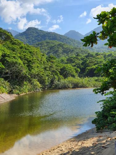 a river with trees and mountains in the background at Pousada Korui in Abraão