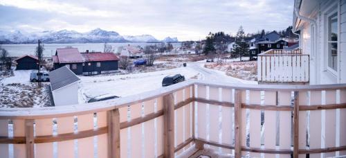 a balcony with a view of a town with snow at Destination Senja - Skaland in Skaland