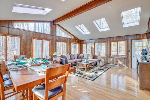 a dining room with a table and chairs and skylights at Bear Haven Cabin - Ski/Lake/Pool with Game Room! in Gouldsboro