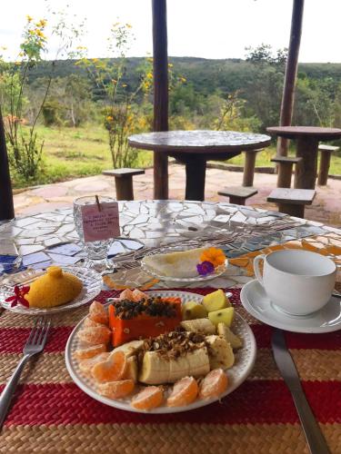 ヴァレ・ド・カパオンにあるPousada Pé do Morroの食べ物の皿とコーヒーカップが置かれたテーブル