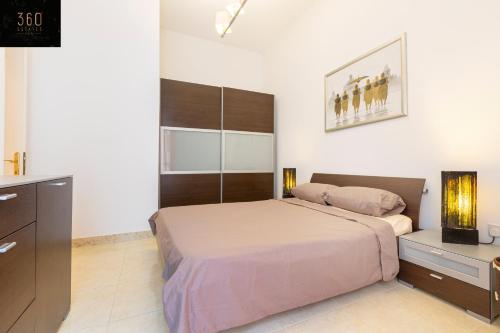 una camera con un letto e un comò di Central APT 5mins to promenade with SOFA AC & WIFI by 360 Estates a Sliema