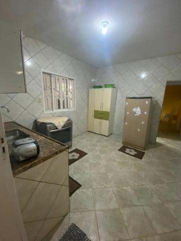 uma casa de banho com um lavatório e um frigorífico em Maria Dajuda em Guarapari