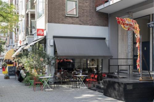 a restaurant with tables and chairs outside of a building at the bellhop in Rotterdam