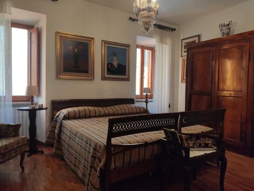 a bedroom with a bed and two chairs and a chandelier at Rua dell'arco n.11 in Ascoli Piceno