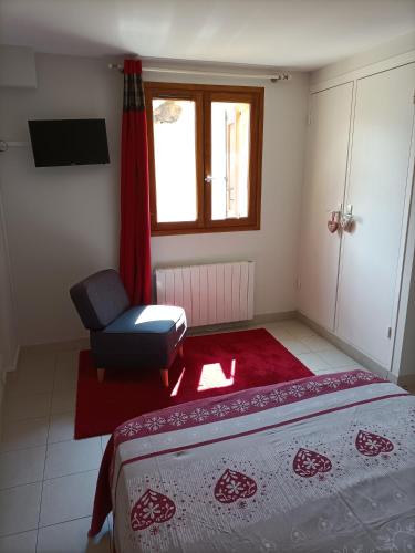 a bedroom with a bed and a chair and a window at Auberge l'écureuil in Châteauneuf-dʼEntraunes