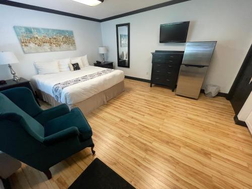 a bedroom with a bed and a television and a chair at Monastery Hotel in St. John's