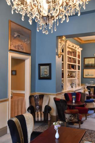a living room with blue walls and a chandelier at The Cranley Hotel in London