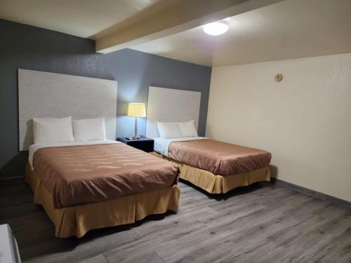 a hotel room with two beds and a lamp at Green Garden Inn in Greensboro