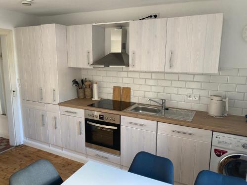 a kitchen with white cabinets and a sink at Ferienhaus Pollerhof in Lindlar