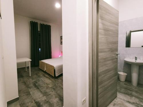een slaapkamer met een bed en een wastafel in een kamer bij Airport Boulevard Guesthouse in Grassobbio