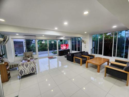 a living room filled with furniture and windows at Psm at Donmueng in Ban Don Muang