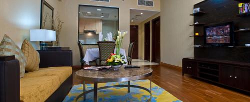 a living room with a couch and a table at Chelsea Gardens Hotel Apartment in Dubai