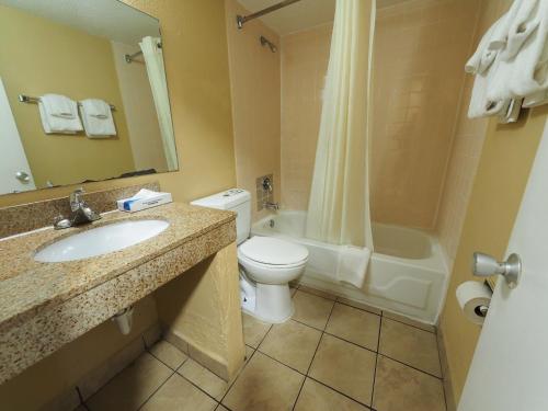 a bathroom with a toilet and a sink and a tub at Econo Lodge Town Center in Virginia Beach