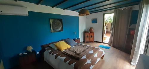 a living room with a couch and a blue wall at Appartement de charme à côté de la plage in La Saline les Bains