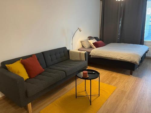 uma sala de estar com um sofá e uma cama em Cosy apartment in the heart of Lahti, free parking em Lahti