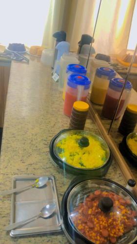 a table with two plates of food on a counter at Hotel Terra Cedro In in Goiânia