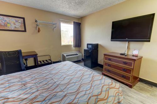 a hotel room with a bed and a flat screen tv at Econo Lodge Virginia Beach Town Center in Virginia Beach