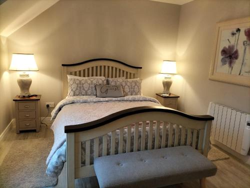 a bedroom with a large bed with two lamps at Dolmen Apartment Carlingford Lough,Omeath in Ó Méith