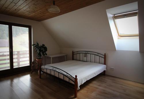 a bedroom with a bed and a large window at Chata Dáša in Vyšný Kubín