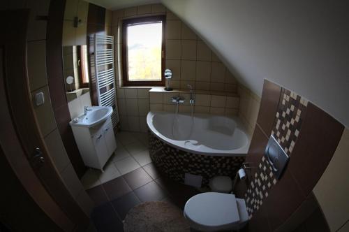 a bathroom with a tub and a toilet and a sink at Chata Dáša in Vyšný Kubín