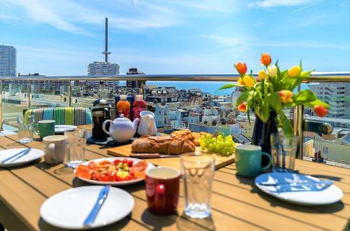 a table with food and a view of a city at SeaBrighton Penthouse with private sea view roof terraces in Brighton & Hove