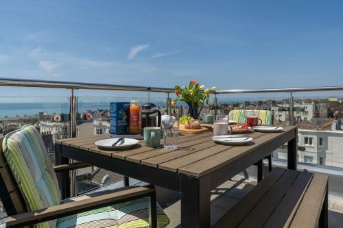 a wooden table on a balcony with a view at SeaBrighton Penthouse with private sea view roof terraces in Brighton & Hove