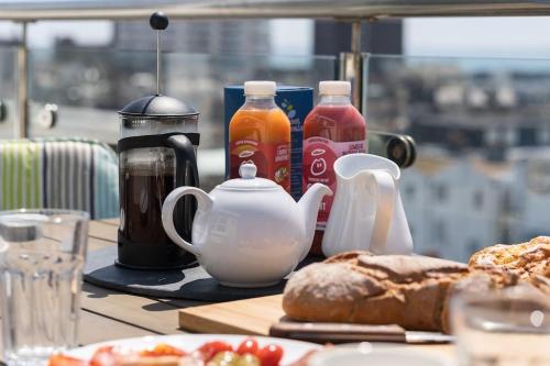 a table with a tea pot and coffee makers and bread at SeaBrighton Penthouse with private sea view roof terraces in Brighton & Hove