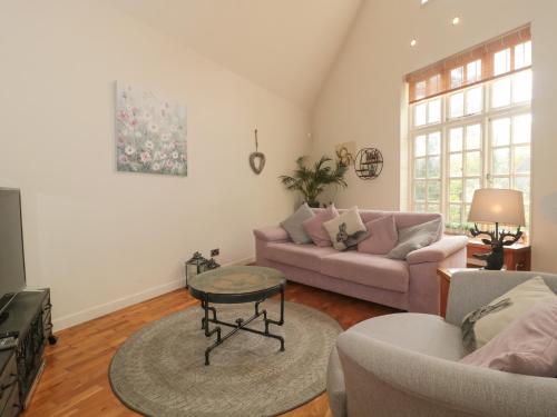 a living room with a couch and a table at Pips Hideaway in Blandford Forum