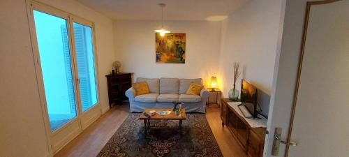 a living room with a couch and a table at Gites Puy Mary et Puy Griou in Saint-Cernin