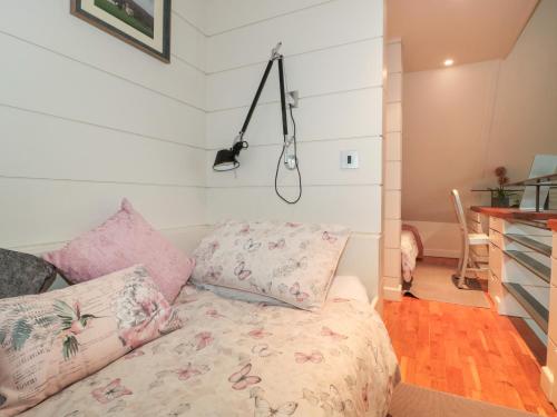 a bedroom with a bed with pink pillows at Pips Hideaway in Blandford Forum