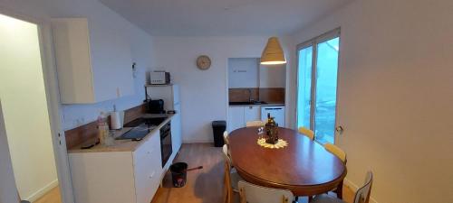 a kitchen with a wooden table and a dining room at Gites Puy Mary et Puy Griou in Saint-Cernin