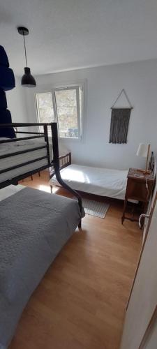 1 dormitorio con cama, escritorio y ventana en Gites Puy Mary et Puy Griou, en Saint-Cernin