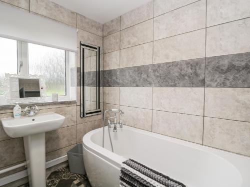 ein Badezimmer mit einer Badewanne, einem Waschbecken und einer Badewanne in der Unterkunft Pool House in Monmouth